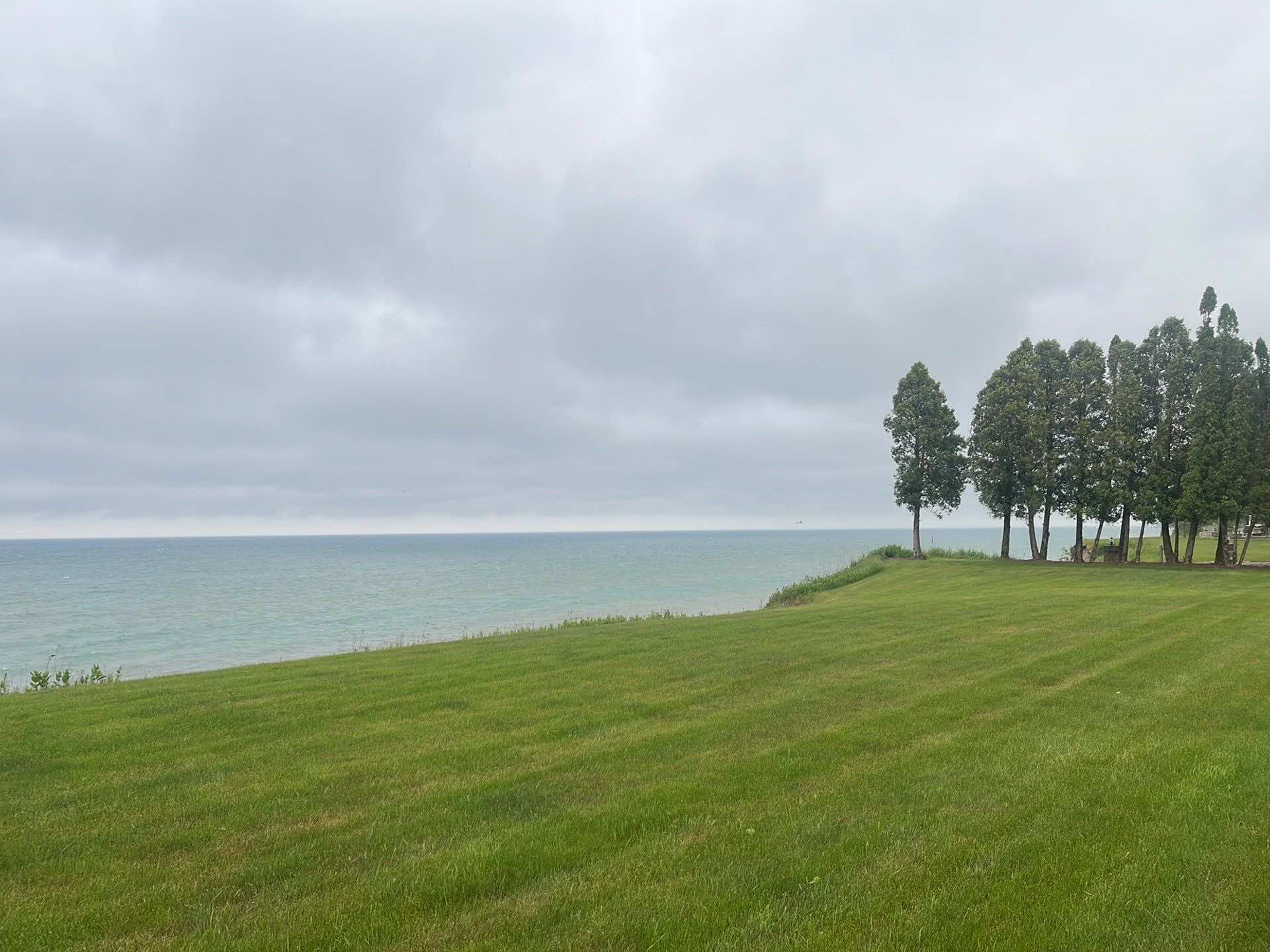 Photo of a backyard on a cliff with Lake Michigan in the background.